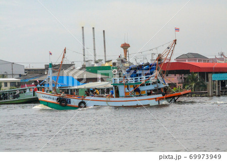 タイランド湾に流れ込むターチン川を走る木造漁船の写真素材