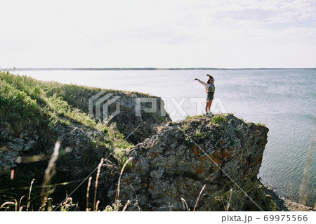 Girl standing on cliff edge 69975566