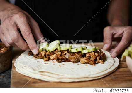 man preparing a durum or a burrito 69975778