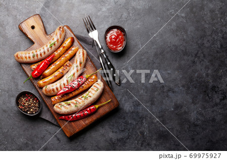 Grilled sausages with spices and herbs 69975927