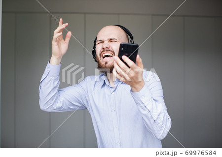 Male feels cheerful mood listening popular tracks online on internet Male feels cheerful mood listening popular tracks online on internet 69976584