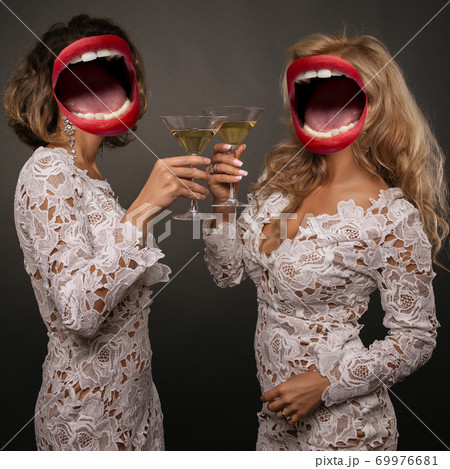 two beautiful young women girlfriends celebrate the holiday with martini glasses two beautiful young women girlfriends celebrate the holiday with martini glasses 69976681