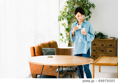 女性 リビング 立つ スマホ コーヒー 女性 リビング 立つ スマホ コーヒー 69979305