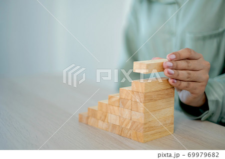Businesswoman hand holding blocks wood game, Concept Risk of management and strategy plan, growth business success process and team work 69979682
