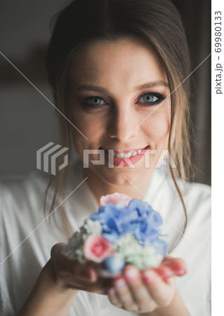 Beautiful bride wearing fashion wedding dress with feathers with luxury delight make-up and hairstyle, studio indoor photo shoot Beautiful bride wearing fashion wedding dress with feathers with luxury delight make-up and hairstyle, studio indoor photo shoot 69980133