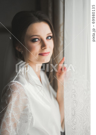 Luxury bride in white dress posing while preparing for the wedding ceremony 69980135