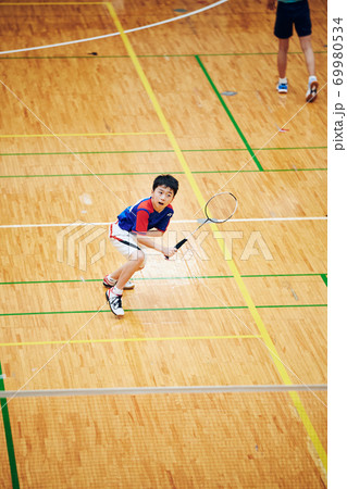 バドミントンの試合をする小学生男子 69980534