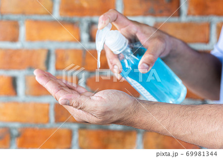 Young man is washing his hands in a sink sanitizing the colona virus for sanitation and reducing the spread of COVID-19 spreading throughout the world, Hygiene ,Sanitation concept. Young man is washing his hands in a sink sanitizing the colona virus for sanitation and reducing the spread of COVID-19 spreading throughout the world, Hygiene ,Sanitation concept. 69981344