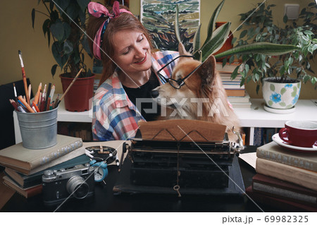 girl and dog corgi typing on a typewriter girl and dog corgi typing on a typewriter 69982325