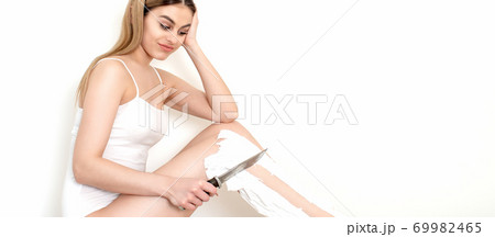 Woman shaves her legs with a knife Woman shaves her legs with a knife 69982465