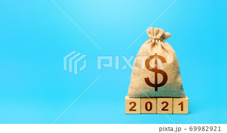 Dollar money bag and blocks 2021. Budget planning for next year. Beginning of new decade. Business plans and development prospects, trends and challenges. Revenues expenses, investment and financing. 69982921