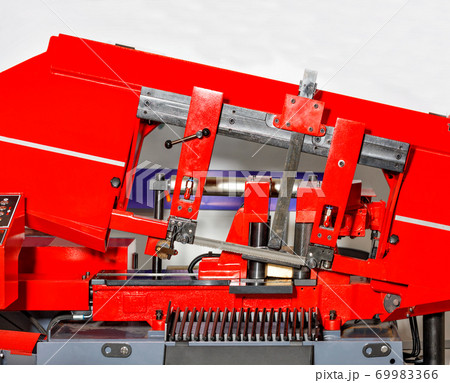 Industrial machine with a band saw for processing large metal parts, close-up. Industrial machine with a band saw for processing large metal parts, close-up. 69983366