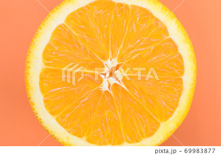 Top view of a one orange fruit slice on bright background in orange color. A saturated citrus texture image Top view of a one orange fruit slice on bright background in orange color. A saturated citrus texture image 69983877