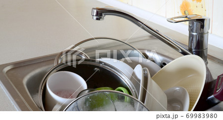 Dirty dishes and unwashed kitchen appliances filled the kitchen sink 69983980