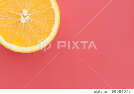 Top view of a one orange fruit slice on bright background in red color. A saturated citrus texture image 69984079