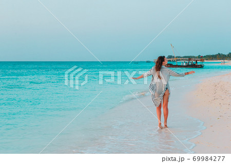 Young fashion woman in green dress on the beach Young fashion woman in green dress on the beach 69984277