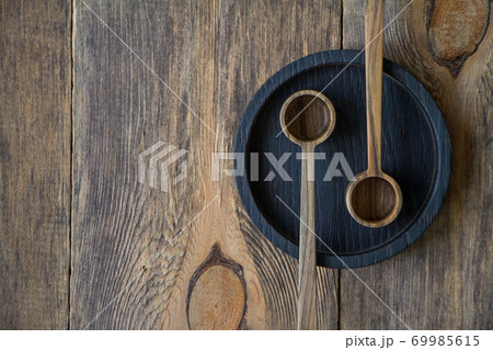 Top view wooden spoons on black plate on wooden table, eco-friendly cutlery concept, selective focus Top view wooden spoons on black plate on wooden table, eco-friendly cutlery concept, selective focus 69985615