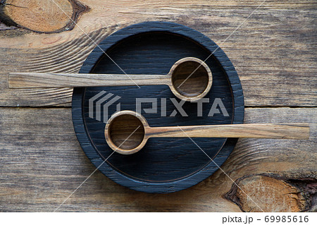 Top view wooden spoons on black plate on wooden table, eco-friendly cutlery concept, selective focus Top view wooden spoons on black plate on wooden table, eco-friendly cutlery concept, selective focus 69985616