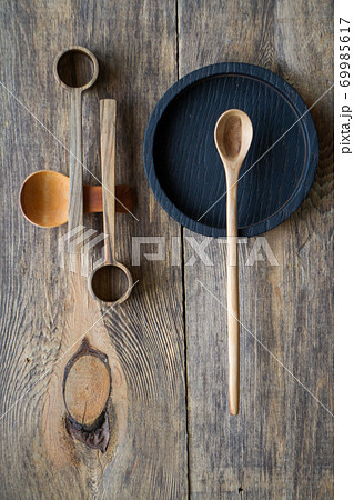 Wooden spoons and plates made of precious wood on wooden table, eco-friendly cutlery concept Wooden spoons and plates made of precious wood on wooden table, eco-friendly cutlery concept 69985617