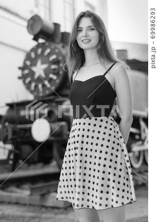 Girl in a white-black dress with polka dots. Black and white photo. BW 69986293