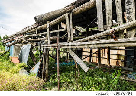 放棄され廃屋になった山奥の木造の建物 69986791