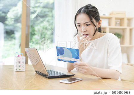 通帳を見る若い女性 通帳を見る若い女性 69986963