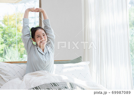 ベッドで目覚めた女性 69987089
