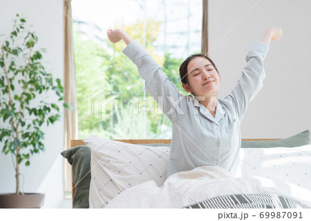 ベッドで目覚めた女性 69987091