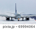 雪煙を巻き上げて着陸する航空機 69994064