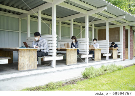 テラス席で仕事をする男女 69994767