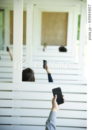 スマホを掲げる男女 スマホを掲げる男女 69994807