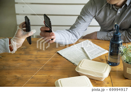 デリバリースタッフとスマホで電子決済するミドルの男性 デリバリースタッフとスマホで電子決済するミドルの男性 69994917