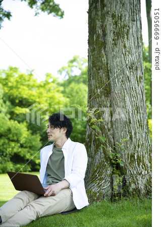 芝生の上で仕事をするミドルの男性 69995051