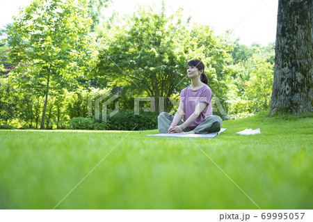 芝生の上でリラックスする女性 69995057