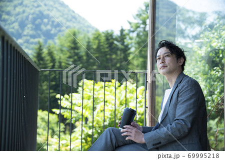 バルコニーでリラックスするビジネスマン 69995218