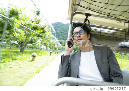 ゴルフカートに乗って仕事をするミドルの男性 ゴルフカートに乗って仕事をするミドルの男性 69995237