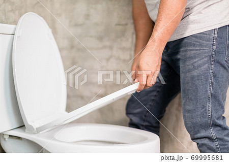 Man lifting up the toilet cover before peeing. Home sanitary concept Man lifting up the toilet cover before peeing. Home sanitary concept 69995681