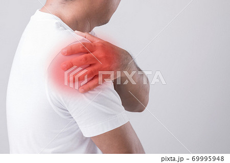 Close up man touching his shoulder and feeling a pain. Studio shot isolated on grey background with copy space for text Close up man touching his shoulder and feeling a pain. Studio shot isolated on grey background with copy space for text 69995948
