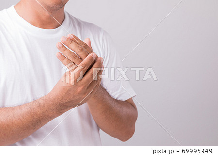 Close up man touching palm and feeling a pain. Studio shot isolated on grey background with copy space for text Close up man touching palm and feeling a pain. Studio shot isolated on grey background with copy space for text 69995949