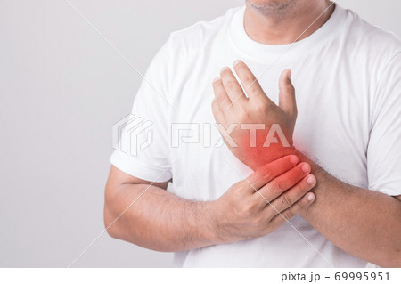 Close up man touching his Wrist and feeling a pain. Studio shot isolated on grey background with copy space for text Close up man touching his Wrist and feeling a pain. Studio shot isolated on grey background with copy space for text 69995951