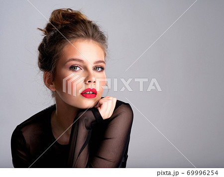 Beautiful photoshopped brown-hair girl. Attractive girl with bright makeup looking at the camera. 69996254