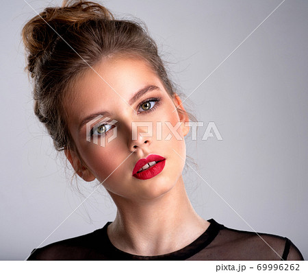Beautiful photoshopped brown-hair girl.  Pretty caucasian girl with  a tilted head and red lipstick. 69996262