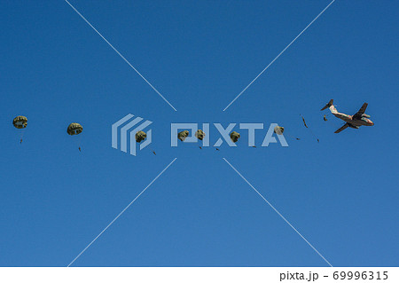 降下訓練始めで輸送機から次々と脱出する落下傘隊員 69996315