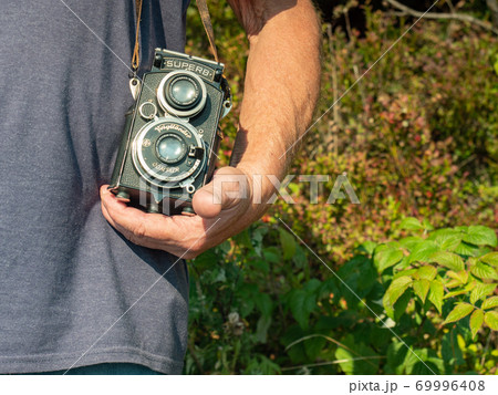 Old photographer use analog camera. Senior man relax Old photographer use analog camera. Senior man relax 69996408