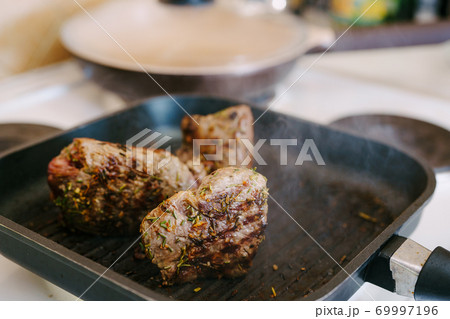 Four toasted steaks on a grilled pan, with finely chopped rosemary. Four toasted steaks on a grilled pan, with finely chopped rosemary. 69997196