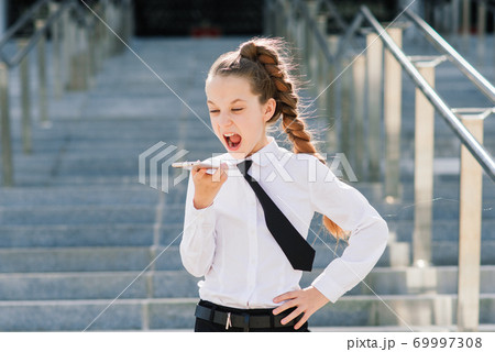 Little school girl having phone talk with friend. modern life communication. Living in digital age. 69997308