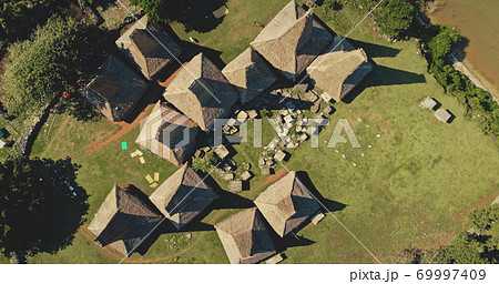 Aerial top down Indonesia farmland with ornated roofs houses at Kodi village landscape, Sumba Island 69997409