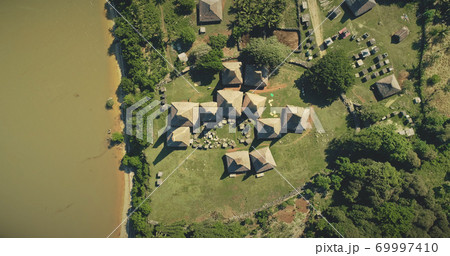 Aerial top down tropic countryside with ornately roofs cottages, houses of traditional village 69997410