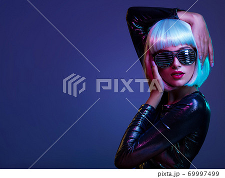Stylish blonde in shiny dress and sunglasses with stresses. Closeup face of beautiful fashionable woman in white wig. Art portrait of an young attractive model. Fantasy style. Glamour fashion girl Stylish blonde in shiny dress and sunglasses with stresses. Closeup face of beautiful fashionable woman in white wig. Art portrait of an young attractive model. Fantasy style. Glamour fashion girl 69997499