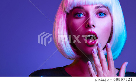 Surprised Face of glamour girl. Wondered female face in a white wig. Young beautiful woman with a shocked face. Art portrait of an young attractive woman with hands at face. Emotional person. Surprised Face of glamour girl. Wondered female face in a white wig. Young beautiful woman with a shocked face. Art portrait of an young attractive woman with hands at face. Emotional person. 69997521